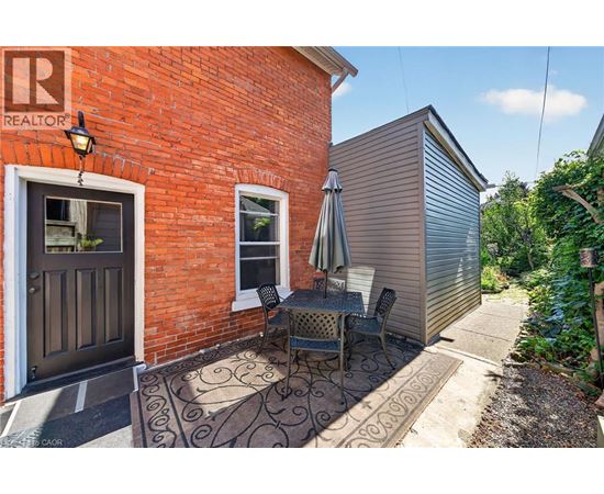A patio with a table and chairs is in front of a red brick building.