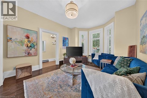 A living room with a blue couch and a glass coffee table.