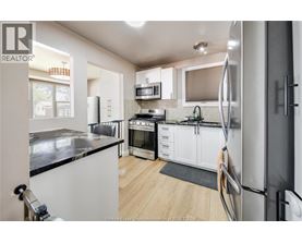 A kitchen with white cabinets and a black counter top.
