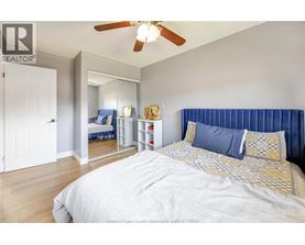 A bedroom with a large bed and a ceiling fan.