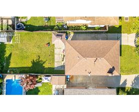 A house with a brown roof and a swimming pool in the backyard.