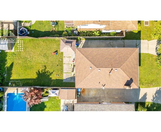 A house with a brown roof and a swimming pool in the backyard.