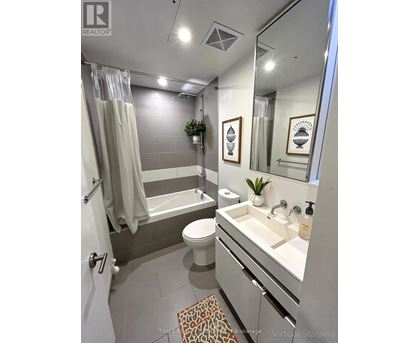 A bathroom with a toilet, sink, and bathtub.