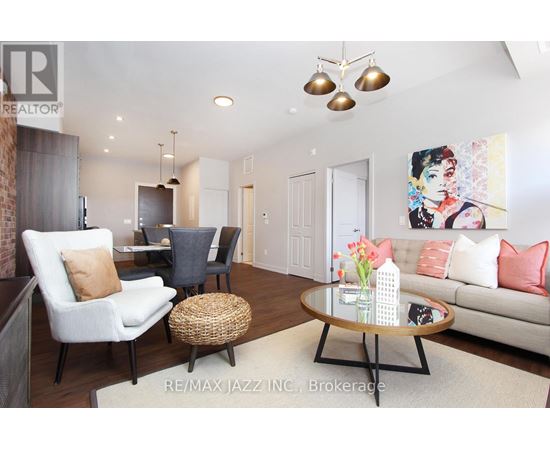 A living room with a white couch, a coffee table, and a painting on the wall.