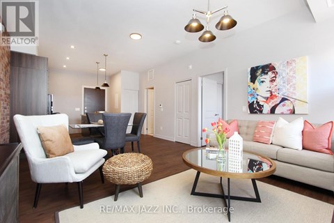 A living room with a white couch, a coffee table, and a painting on the wall.