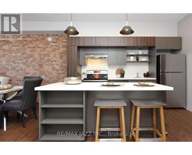 A modern kitchen with a brick wall and a dining area.