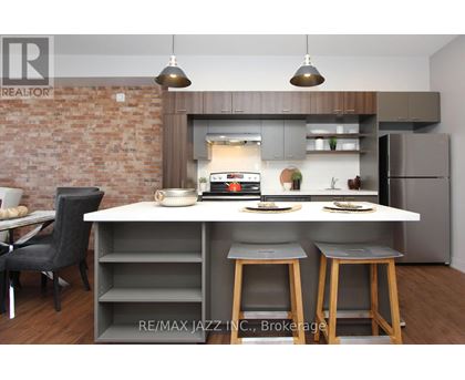 A modern kitchen with a brick wall and a dining area.