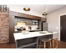 A modern kitchen with a brick wall and a white countertop.