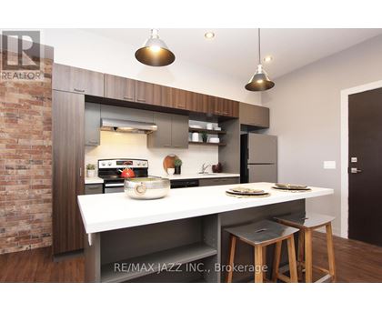 A modern kitchen with a brick wall and a white countertop.