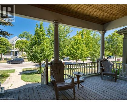 A porch with two chairs and a table.