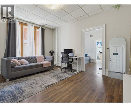 A living room with a grey couch and a wooden floor.