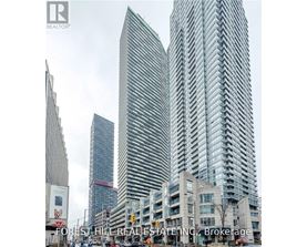 A tall building with a curved facade stands in front of a smaller building.