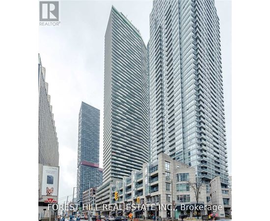 A tall building with a curved facade stands in front of a smaller building.