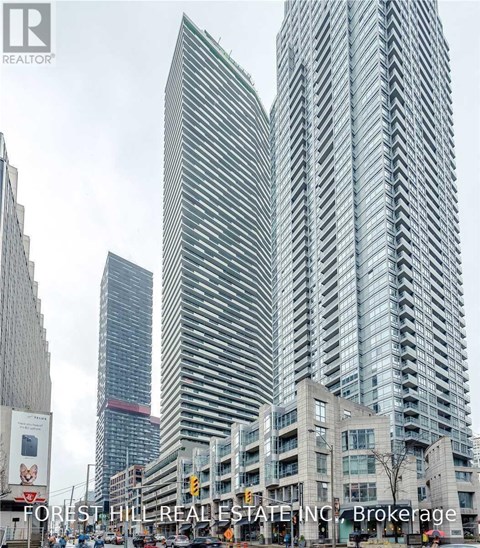 A tall building with a curved facade stands in front of a smaller building.