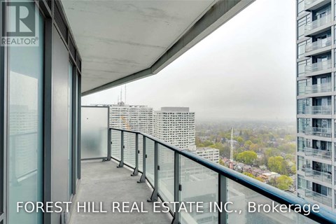 A balcony with a glass railing and a view of the city.