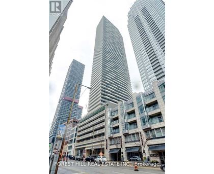 A tall building with a curved facade stands in front of two other buildings.