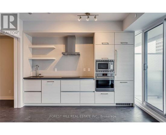 A modern kitchen with white cabinets and stainless steel appliances.