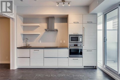 A modern kitchen with white cabinets and stainless steel appliances.