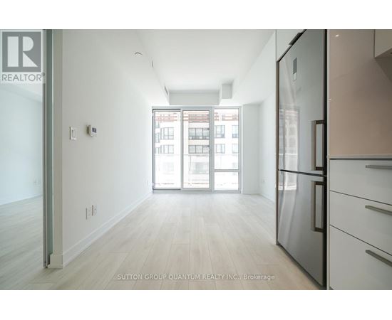 A kitchen with a refrigerator and a view of a building outside.