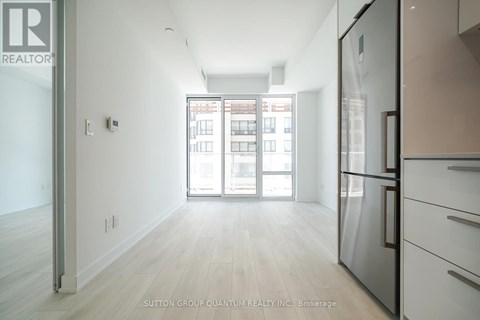 A kitchen with a refrigerator and a view of a building outside.