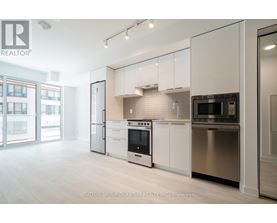 A modern kitchen with white cabinets and stainless steel appliances.