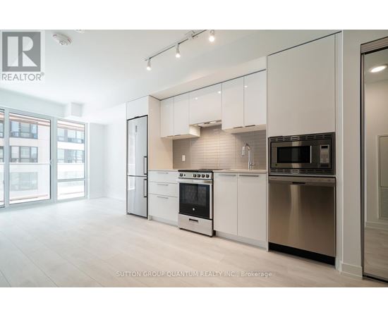A modern kitchen with white cabinets and stainless steel appliances.