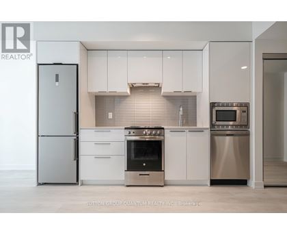 A modern kitchen with stainless steel appliances and white cabinets.
