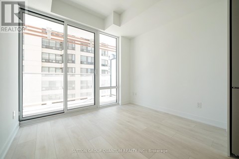 A room with a view of a building through the window.