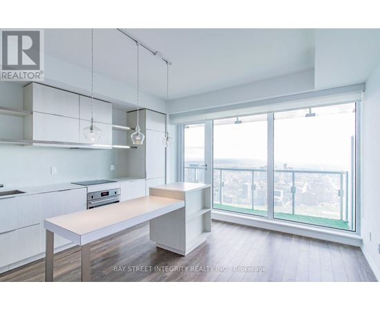 A kitchen with white cabinets and a wooden island.
