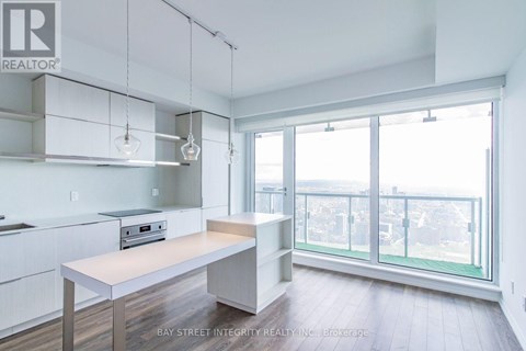 A kitchen with white cabinets and a wooden island.