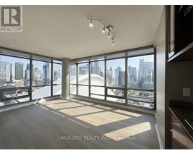 A spacious room with large windows overlooking a cityscape.