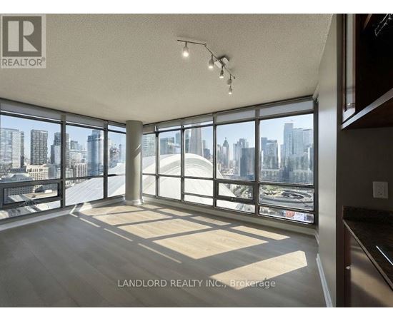 A spacious room with large windows overlooking a cityscape.