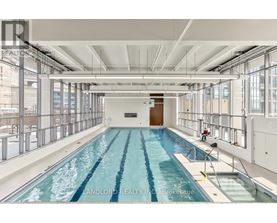 A large indoor swimming pool with a diving board.
