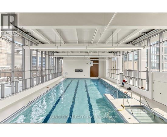 A large indoor swimming pool with a diving board.