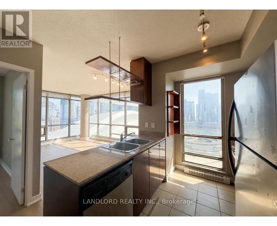 A kitchen with a large island and a view of the city outside the window.
