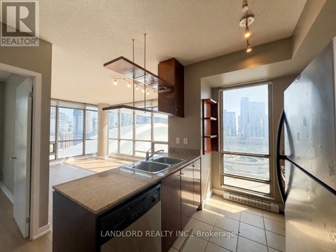 A kitchen with a large island and a view of the city outside the window.