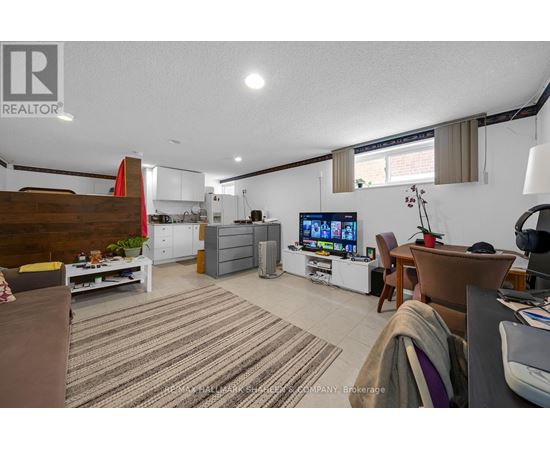 A living room with a TV, a couch, and a dining table.