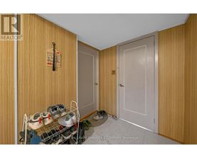 A brokerage sign is on the door of a room with a shoe rack and a pair of shoes.