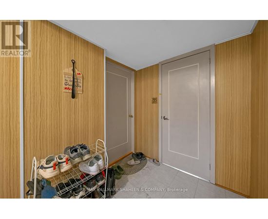 A brokerage sign is on the door of a room with a shoe rack and a pair of shoes.