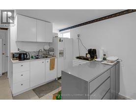 A kitchen with white cabinets and a glass island.