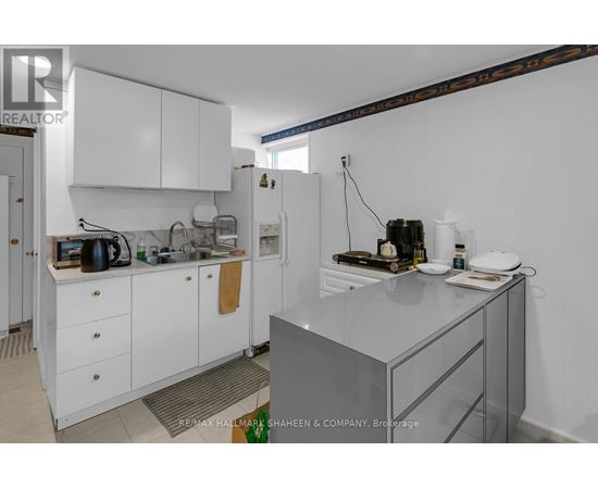 A kitchen with white cabinets and a glass island.