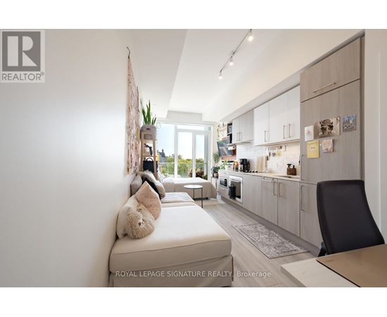 A modern kitchen with white cabinets and a dining table with a black chair.