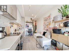 A kitchen with a dining area and a bed in the living room.