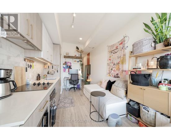 A kitchen with a dining area and a bed in the living room.