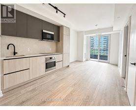 A modern kitchen with wooden floors and a large window.