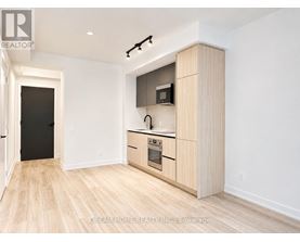 A modern kitchen with wooden floors and cabinets.
