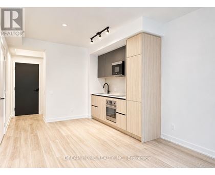 A modern kitchen with wooden floors and cabinets.