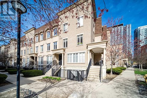 A beige building with a black railing in front.