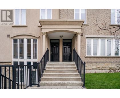 A beige building with a black door and a sign that says REALTOR.