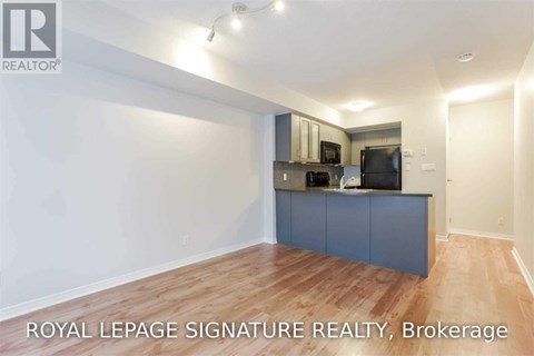 A spacious kitchen with a blue cabinet and wooden flooring.